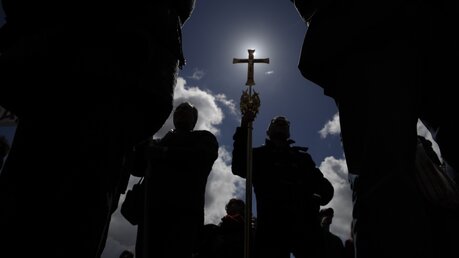 Ein Gläubiger hält auf dem Petersplatz während des Angelus-Gebets ein Kreuz / © Alessandra Tarantino (dpa)