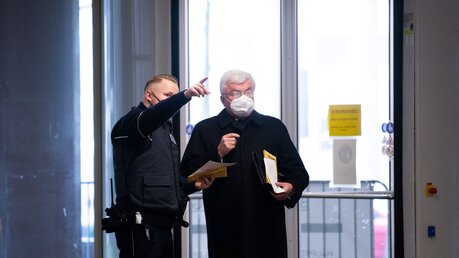 Ein Justizbeamter erklärt Günter Assenmacher, früherer Kirchenrichter des Erzbistums Köln, den Weg zum Gerichtssaal / © Federico Gambarini (dpa)