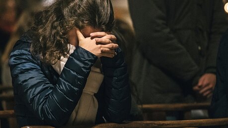 Eine junge Frau betet für die Opfer von Missbrauch durch Kirchenmitglieder / © Fabrice Caterini-Inediz (KNA)