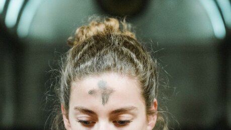 Eine junge Frau mit einem Aschekreuz auf der Stirn / © Corinne Simon (KNA)