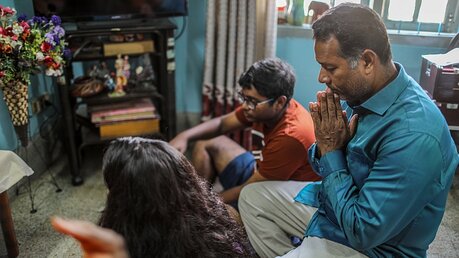 Eine katholische Familie betet zusammen zu Hause im Wohnzimmer in Dhaka (Bangladesch). / © Turjoy Chowdhury (KNA)