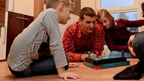 Familie spielt ein Gesellschaftsspiel / © Harald Oppitz (KNA)