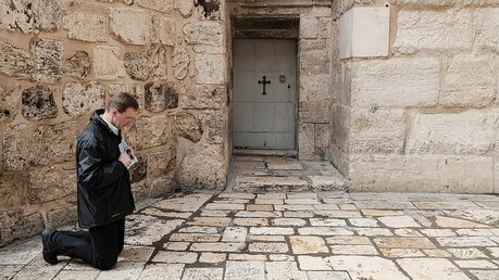Gläubiger betet vor den geschlossenen Türen der Grabeskirche / © Nir Alon (dpa)