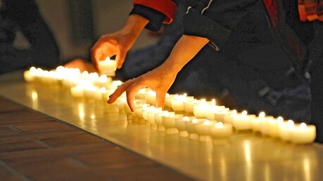 Gläubige stellen Kerzen auf / © Jens Schulze (epd)