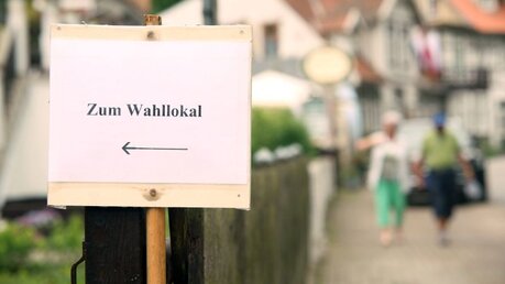 Hinweisschild zu einem Wahllokal / © Matthias Bein (dpa)