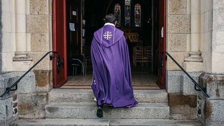 Ein Priester betritt eine Kirche / © Jean-Matthieu Gautier (KNA)
