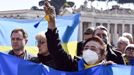 Eine Frau hält auf dem Petersplatz eine gelb-blaue Fahne der Ukraine in den Händen / © Paolo Galosi/Romano Siciliani (KNA)