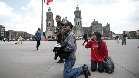 Mexiko-Stadt: Menschen telefonieren, nachdem sie einen Erdbebenalarm auf dem Zocalo-Platz gehört haben / © Francisco Canedo (dpa)