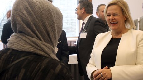Nancy Faeser (SPD), Bundesinnenministerin, nimmt im Bundesinnenministerium an der Deutschen Islamkonferenz teil und unterhält sich mit Konferenzteilnehmern. / © Wolfgang Kumm (dpa)