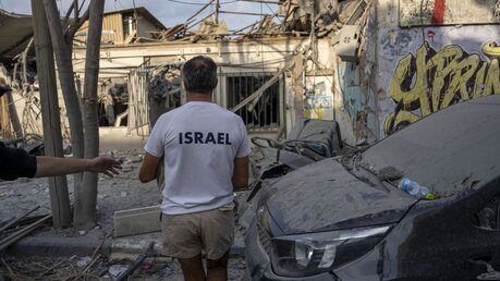 Israelis inspizieren die Trümmer eines Gebäudes, einen Tag nachdem es von einer aus dem Gazastreifen abgefeuerten Rakete getroffen wurde / © Oded Balilty/AP (dpa)