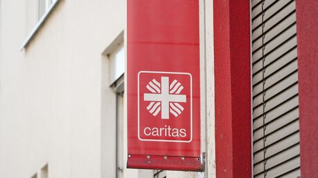 Banner mit dem Logo der Caritas  / © Harald Oppitz (KNA)