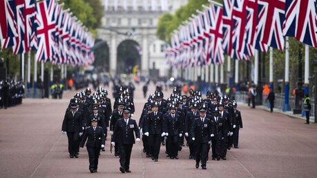 London: Polizeibeamte gehen vor der Staatsakt zur Beisetzung von Königin Elizabeth II. über die Prachtstraße The Mall / © Vadim Ghirda (dpa)