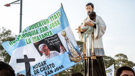 Eine Heiligenfigur und eine argentinische Flagge mit Sprüchen und einem Bild von Papst Franziskus. / © Mariano Campetella (KNA)