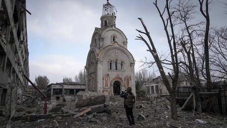 Ein ukrainischer Soldat fotografiert eine beschädigte Kirche in Mariupol / © Evgeniy Maloletka/AP (dpa)