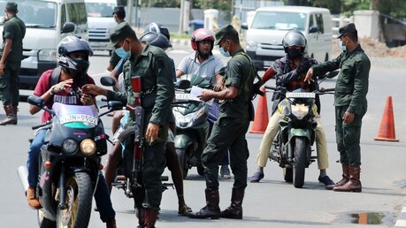 Soldaten der srilankischen Armee kontrollieren die Papiere von Motorradfahrern während der Ausgangssperre / © Ajith Perera (dpa)