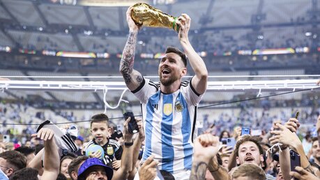 Argentiniens Lionel Messi lässt sich mit dem Weltmeisterpokal feiern / © Tom Weller (dpa)