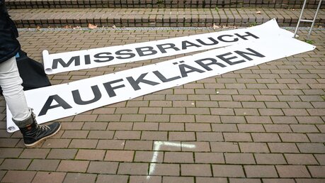 Banner mit der Aufschrift "Missbrauch aufklären"  / © Julia Steinbrecht (KNA)