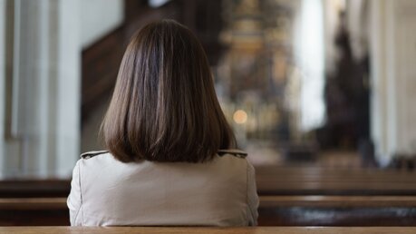 Frau in einer Kirche im Gebet / © No-Te Eksarunchai (shutterstock)