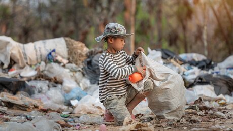 Ein Kind durchsucht Müll / © Tinnakorn jorruang (shutterstock)