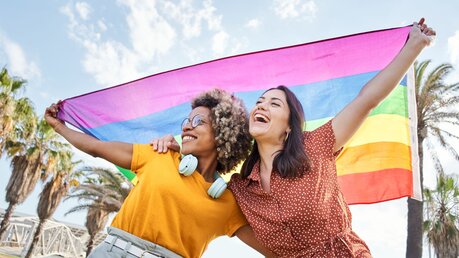 Homosexuelles Paar mit Regenbogenfahne / © CarlosBarquero (shutterstock)