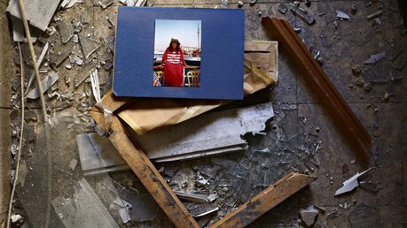 Israel, Petah Tikva: Ein Bild und ein zerbrochener Rahmen liegen in den Trümmern einer Wohnung / © Oded Balilty (dpa)