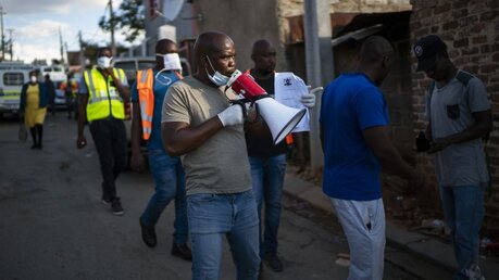 Johannesburg: Südafrikanische Gemeinde-Aktivisten fordern die Menschen auf, in ihren Häusern zu bleiben / © Jerome Delay (dpa)