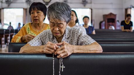 Katholiken beten in einer Kirche in Bangkok / © Jack Kurtz (dpa)