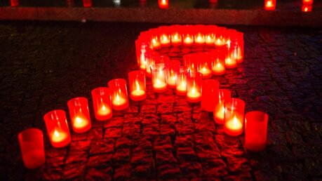 Kerzen bilden eine rote Schleife als ein Symbol für den Kampf gegen Aids / © Florian Schuh (dpa)