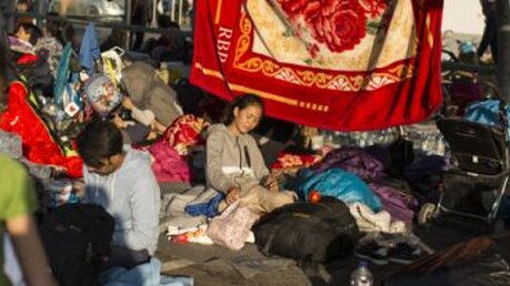 Menschen lagern auf einem Supermarkt in der Nähe des ausgebrannten Flüchtlingslagers Moria / © Socrates Baltagiannis (dpa)