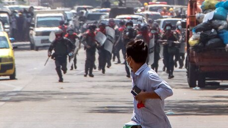 Militärputsch in Myanmar: Bereitschaftspolizisten rennen einem Demonstranten nach / © Santosh Krl (dpa)