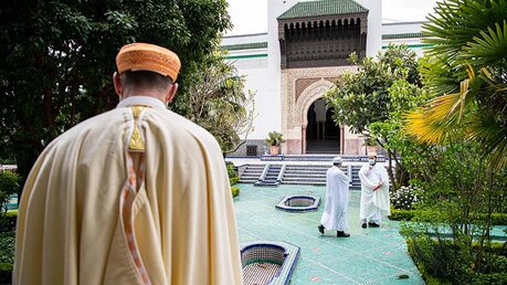 Muslimische Männer unterhalten sich im Garten der Großen Moschee in Paris. / © Corinne Simon (KNA)