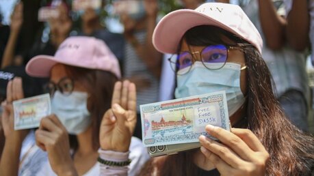 Myanmar: Demonstranten zeigen den Drei-Finger-Gruß und Geldscheine mit geschriebenen Slogans / © Uncredited (dpa)