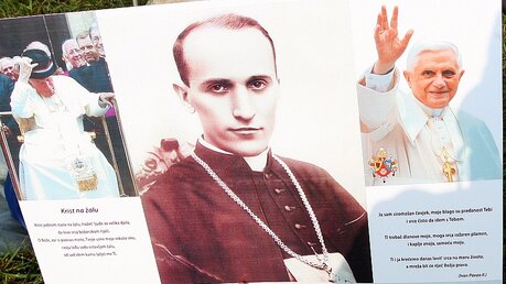 Ein Plakat mit John Paul II (links) Bischof Aloizie Stepinac (mitte) und Benedict XVI (rechts) / © Antonio Bat (dpa)