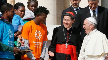 Papst Franziskus mit Kardinal Luis Antonio Tagle (z.v.r.) und Migranten / © Paul Haring (KNA)