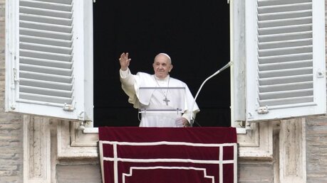 Papst Franziskus winkt aus seinem Fenster, während er das Angelus-Gebet auf dem Petersplatz spricht / © Gregorio Borgia/AP (dpa)