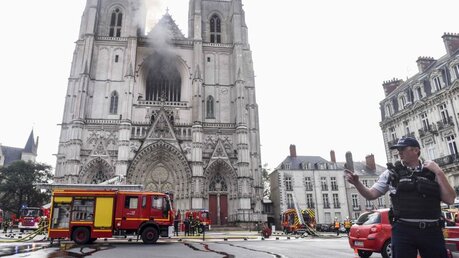 Polizist vor der Kathedrale von Nantes nach dem Brand / © Sebastien Salom-Gomis/AFP (dpa)