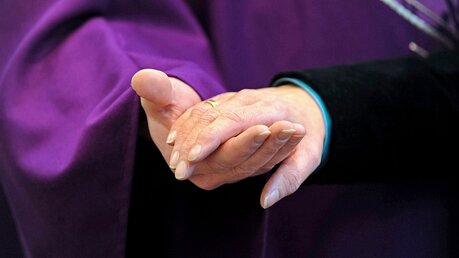 Ein Priester hält eine Frauenhand mit Ehering / © Paul Sklorz (KNA)