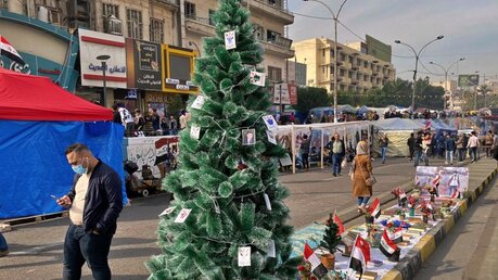 Proteste im Irak – An einem Weihnachtsbaum hängen Bilder von regierungskritischen Demonstranten, die während Zusammenstößen mit Sicherheitskräften gestorben sind / © Khalid Mohammed (dpa)
