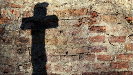 Symbolbild Missbrauch, Schatten eines Kreuzes / © Taigi (shutterstock)