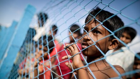 Flüchtlinge an einem Grenzzaun / © Kay Nietfeld (dpa)