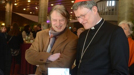 Verleger Frank Steffan schenkt Kardinal Woelki ein FC-Buch / © Beatrice Tomasetti (DR)