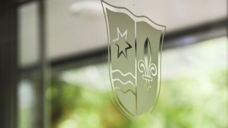 Wappen des Aloisiuskollegs an einer Tür des Schulgebäudes / © Julia Steinbrecht (KNA)