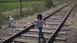 Ein kleines M&auml;dchen l&auml;uft auf Bahnschienen an der serbisch-ungarischen Grenze (KNA)