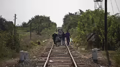 Fl&uuml;chtlinge laufen auf Bahngleisen in Ungarn (KNA)