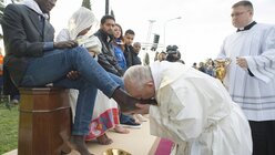 Papst Franziskus wäscht in der Asylunterkunft in Castelnuovo di Porto während der Gründonnerstagsmesse am 24. März 2016 Flüchtlingen und Migranten die Füße. Bild: Papst Franziskus küsst die Füße eines Migranten. (KNA)