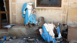 Beschädigte Heiligenfiguren zwischen den Trümmern der teilweise zerstörten christlichen syrisch-katholischen Kirche Sankt Georg in Bartella. / © Uygar Onder Simsek (KNA)
