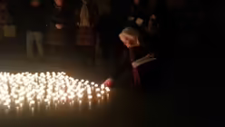 Eine Frau stellt ein Licht zur Lichtinsel / &copy; Hartmann (DR)