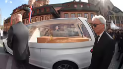 Kardinal Lehmann wird in einem Holzsarg transportiert (dpa)