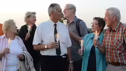 Als die Sonne längst untergegangen ist, halten die Menschen Kerzen in den Händen. / © Beatrice Tomasetti (DR)