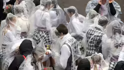 Bei dem Regen helfen nur Regenponchos. / © Federico Gambarini (dpa)